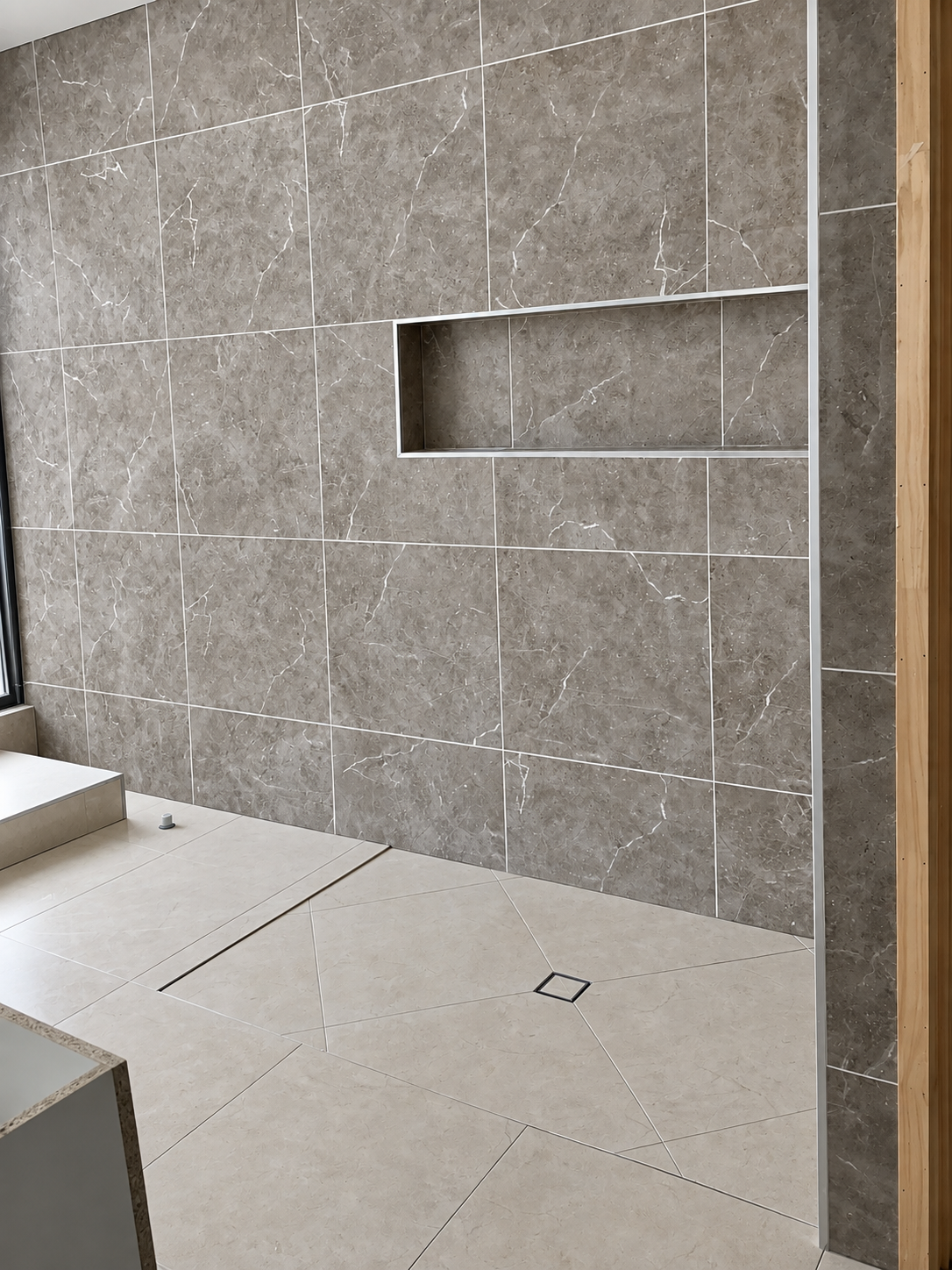 Marble-look feature wall with long tiled niche and shower floor